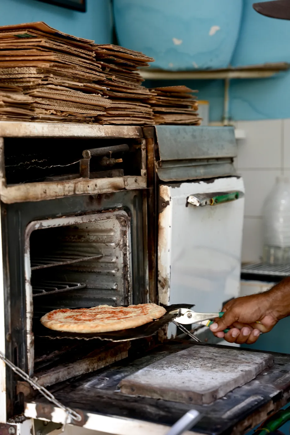 A wood-fired oven in Cuba, a pizza coming out on the peel