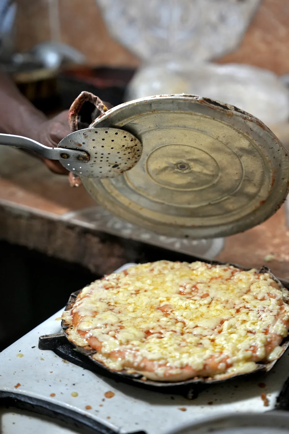 A just-baked pizza on the peel, still over the oven