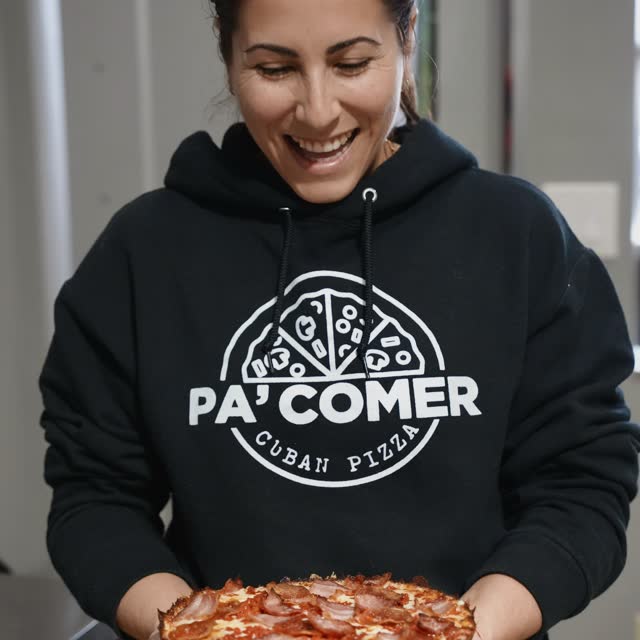 Elizabeth holding a Cuban pizza fresh out of the oven