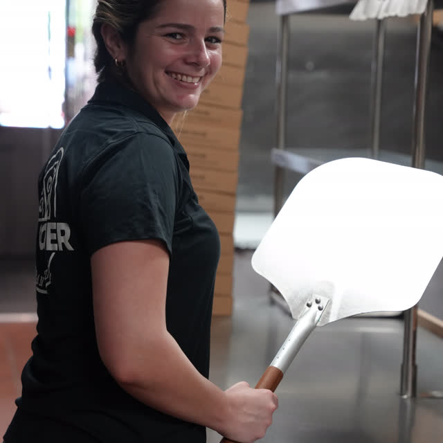 Part of the Pa’ Comer team holding the oven peel